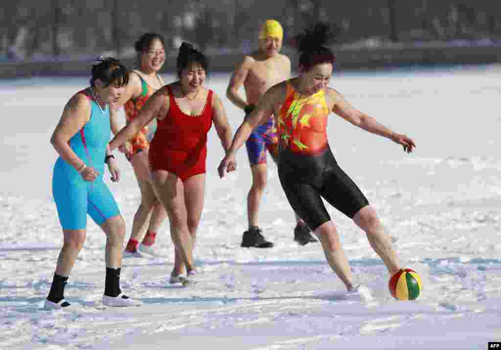 Chinese women run with a ball on a snow covered field in Shenyang in China&#39;s northeastern Liaoning province during International Women&#39;s Day.