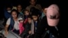 ARCHIVO - Familias migrantes solicitantes de asilo viajan en una balsa inflable mientras cruzan el río Grande hacia los Estados Unidos desde México en Roma, Texas, EE. UU., 8 de junio de 2021.
