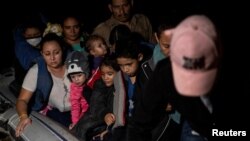 ARCHIVO - Familias migrantes solicitantes de asilo viajan en una balsa inflable mientras cruzan el río Grande hacia los Estados Unidos desde México en Roma, Texas, EE. UU., 8 de junio de 2021.