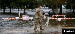 An Army member walks near the flooded Union Point Park Complex as Hurricane Florence draws closer to the coast in New Bern, N.C., Sept. 13, 2018.