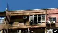 In this photo released by the Syrian official news agency SANA, damaged apartments are seen after a clashes between the Syrian rebels and the Security forces, in the Mazzeh neighborhood of Damascus, Syria, on Monday, March 19, 2012.