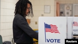 A man fills out a ballot at a voting site as Democrats and Republicans hold their Michigan primary presidential election, in Detroit, Michigan, Feb. 27, 2024.
