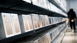 A man browses an iPhone unit on display at a section selling Apple's products together with Chinese made electric appliances at a hypermarket in Beijing, Thursday, May 9, 2019. 