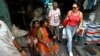 Tourists walk through Dharavi, one of Asia's largest slums, during a guided tour as local residents look on in Mumbai November 28, 2007.