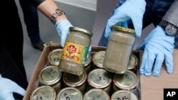 FILE - Investigators display confiscated jars filled with heroin at the headquarters of the federal police in Wiesbaden, Germany, Oct. 9, 2014.