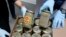 FILE - Investigators display confiscated jars filled with heroin at the headquarters of the federal police in Wiesbaden, Germany, Oct. 9, 2014.