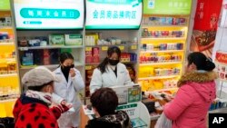 Staff sell masks at a Yifeng Pharmacy in Wuhan, Chin, Jan. 22, 2020. 