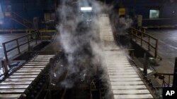 FILE - A worker supervises the filling of aluminum bars in Venalum, in Ciudad Guayana, Bolivar state, Venezuela, Nov. 6, 2017. 