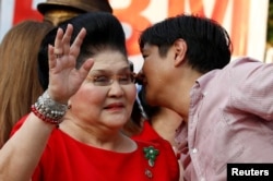 FILE - Philippines Vice-Presidential candidate BongBong Marcos whispers to his mother, former First Lady and Congresswoman Imelda Marcos, before BongBong announced his candidacy in Manila Philippines, October 10, 2015.