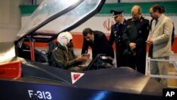 Presiden Iran Mahmoud Ahmadinejad (tengah) mendengarkan katerangan dari seorang pilot dalam upacara peluncuran pesawat jet tempur baru buatan Iran, Qaher-313, atau disebut juga Dominant-313,di Teheran, Iran, 2 Februari 2013. (AP Photo/Mehr News Agency, Younes Khani)