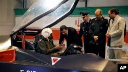 Presiden Iran Mahmoud Ahmadinejad mendengarkan penjelasan pilot pesawat jet tempur Qaher. (Foto: AP)
