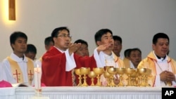 In this photo released by Henan Catholic, Rev. Joseph Zhang Yinlin, second left, takes part in an ordination ceremony to be named coadjutor bishop of Anyang, in Anyang city in central China's Henan province, Aug. 4, 2015.