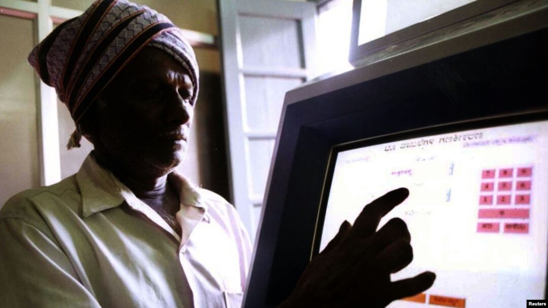 FILE - An Indian farmer uses a computer to check land records in Ramanagaram, in the southern state of Karnataka, May 26, 2001. Land records in most Indian states date to the colonial era, and most land holdings have uncertain ownership. Fraud is rampant.