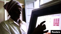 FILE - An Indian farmer uses a computer to check land records in Ramanagaram, in the southern state of Karnataka, May 26, 2001. Land records in most Indian states date to the colonial era, and most land holdings have uncertain ownership. Fraud is rampant.