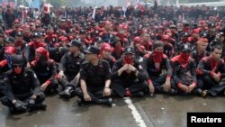 Hundreds of demonstrators block the road outside the parliament building, while parliament members hold a meeting to pass the mass organization bill, in Jakarta, July 2, 2013.