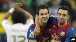 Pemain Barcelona Cesc Fabregas (tengah) dengan Xavi Hernandez (kanan) merayakan kemenangan timnya melawan Real Madrid dalam Pertandingan Liga Spanyol di Stadion Santiago Bernabeu,Madrid (foto:dok)