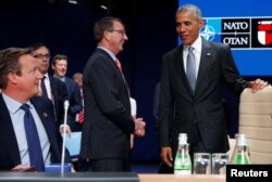 U.S. President Barack Obama, right, speaks with U.S. Defense Secretary Ash Carter, center, and Britain's Prime Minister David Cameron during a working session of the North Atlantic Council at the NATO Summit in Warsaw, Poland July 9, 2016.
