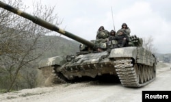 FILE - A tank of the self-defense army of Nagorno-Karabakh moves on the road near the village of Mataghis, April 6, 2016.