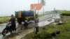 Beberapa pria di tengah hujan di kecamatan Sumur, Provinsi Banten, yang terdampak tsunami, 26 Desember 2018. (Foto: Reuters)