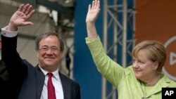 Nemačka kancelarka Angela Merkel i Armin Lašet, vodeći demohrišćanski kandidat u Severnoj Rajni - Vestfaliji, pozdravljaju pristalice tokom predizborne kampanje u Ahenu, Nemačka, 13. maja 2017. (Oliver Berg/dpa via AP)