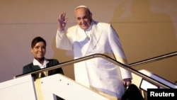 Pope Francis waves as he boards a plane for his trip to Sri Lanka and Philippines at Fiumicino airport in Rome, Jan. 12, 2015. 