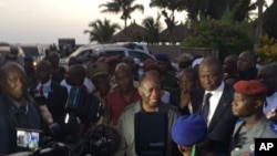 Ivory Coast's President Alassane Ouattara, center, visits the area where gunmen attacked people in Grand Bassam, Ivory Coast, March 13, 2016.