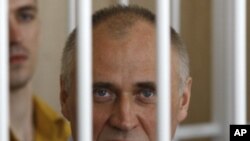 A former opposition presidential candidate Nikolai Statkevich sits in a cage during a court session in Minsk, Belarus, Thursday, May 26, 2011