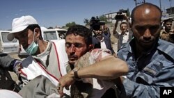 Des manifestants de l'opposition aident un blessé victime des affrontements avec la police, à Sanaa, le samedi 15 octobre 2011 ( Archive)