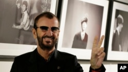 Pop icon and former Beatle Ringo Starr poses for the media in front of some of his photographs during a photocall as he launches a book called 'Photograph' in London, Sept. 9, 2015.