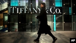 FILE - A woman walks past a Tiffany & Co. store at a shopping mall in Beijing, Nov. 29, 2018. 
