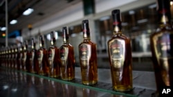 FILE - Bottles of Santa Teresa "Gran Reserva" rum move along the assembly line at the factory in La Victoria, Aragua State, Venezuela, March 26, 2015.