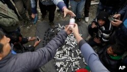 Migrant men display used tear gas canisters apparently used by Macedonian police during yesterday riots at the fence in the makeshift camp of the northern Greek border point of Idomeni, Greece, April 11, 2016.