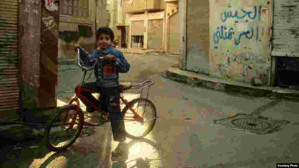 Yaseen on bicycle 30 minutes before a Syrian rocket from a government-held position exploded, killing he and his sister, Maryam, January 20, 2013 (Lens Young Homsi) 