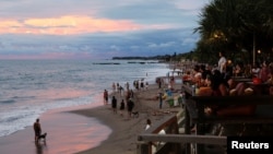 Wisatawan menikmati indahnya suasana matahari terbenam di Pantai Canggu, Bali, 2 Desember 2021. (Johannes P. Christo/REUTERS)