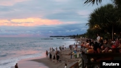 Sejumlah wisatawan tampak menikmati momen matahari terbenam di salah satu pantai di Canggu, Bali, pada 2 Desember 2021. (Foto: Reuters/Johannes P. Christo)