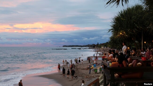 Sejumlah wisatawan tampak menikmati momen matahari terbenam di salah satu pantai di Canggu, Bali, pada 2 Desember 2021. (Foto: Reuters/Johannes P. Christo)