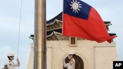 FILE - Dua tentara menurunkan bendera nasional selama upacara bendera harian di Liberty Square di Chiang Kai-shek Memorial Hall di Taipei, Taiwan, 30 Juli 2022. (AP/Chiang Ying-ying)