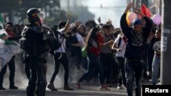 Riot police confront students of public universities during a march in Bogota, Colombia, Dec. 13, 2018. 