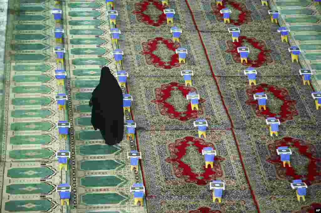 An Iranian woman makes her way between copies of the Quran, Islam&#39;s holy book, prepared for a ceremony during Ramadan at the shrine of Saint Mohammad Helal Ibn Ali in the city of Aran and Bidgol, some 140 miles (225 kilometers) south Tehran.