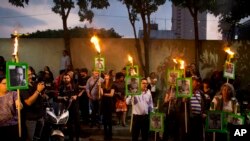 Demonstran berteriak "Keadilan!" sambil membawa poster wartawan yang dibunuh Javier Valdez saat berdemo di luar kantor Departemen Dalam Negeri di Mexico City, 16 Mei 2017.