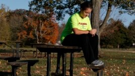 Grace Brown, 14, adjusts her fitness tracker at the park where she does her jogging workouts for her 
