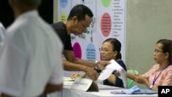 A voter registers to cast his ballot at a polling station in Yangon, Myanmar, Nov. 3, 2018.