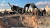 U.S. Soldiers and journalists stand near a crater caused by Iranian bombing at Ain al-Asad air base, in Anbar, Iraq, Jan. 13, 2020. 