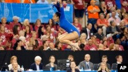 Sophina DeJesus saute de joie après avoir montré sa routine lors d'une compétition de la NCAA à Fort Worth, Texas, le 16 avril 2016.