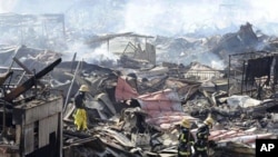 Rescuers conduct search operation amidst smoldering debris in Kesennuma, northern Japan Monday, March 14, 2011 following Friday's massive earthquake and the ensuing tsunami. (AP Photo/Yomiuri Shimbun, Miho Ikeya) JAPAN OUT, MANDATORY CREDIT