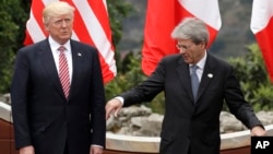 U.S. President Donald Trump, left, and Italian Prime Minister Paolo Gentiloni stand on the podium during a group photo at the G7 Summit in the Ancient Theatre of Taormina in the Sicilian citadel of Taormina, Italy, May 26, 2017. 