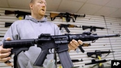 یک فروشنده سلاح در آمریکا یک اسلحه AR-15 را نشان می دهد.