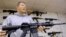 FILE - John Jackson, co-owner of Capitol City Arms Supply, shows off an AR-15 assault rifle for sale, Jan. 16, 2013, at his business in Springfield, Illinois.