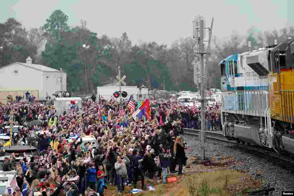 People pay their respects as the train carrying the casket of former President George H.W. Bush passes along the route from Spring to College Station, Texas.