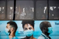 Commuters crowd a bus promoting the use of face masks during the COVID-19 pandemic in Rio de Janeiro, Brazil, July 23, 2021.